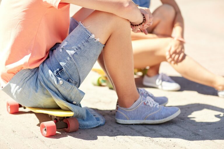 teenage couple with skateboards on city street